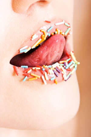 Close-up of young beautiful girl with candy on her lipsの写真素材