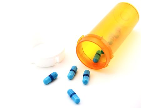 Blue Pills Spilling from Perscription Bottle Isolated on White