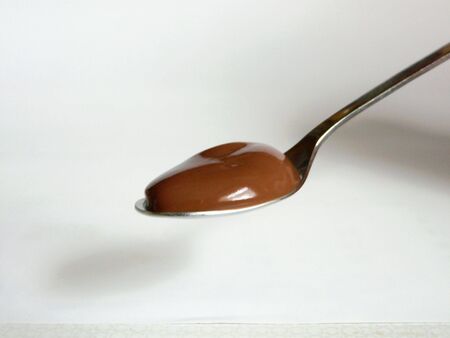 A close up of a spoon with some chocolate pudding on itの写真素材