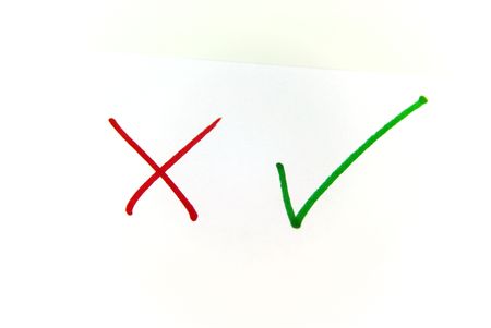 A close up view of a check mark and a cross over whiteの写真素材