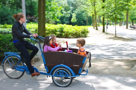 Young girl transporting children in the cart . Amsterdam. Netherlandsのeditorial素材