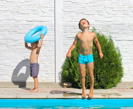 Two brothers near a swimming pool at summer vacationの写真素材
