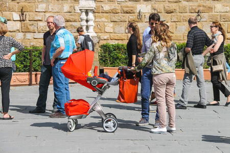 FLORENCE, ITALY - MAY 08, 2014: Young family walking in a summer town. Florence, Italy 