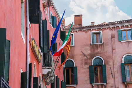 VENICE, ITALY - MAY 06, 2014: Flags of the European Union, Italy and Venice on a facade the hotel Rialto in Venice, Italyのeditorial素材