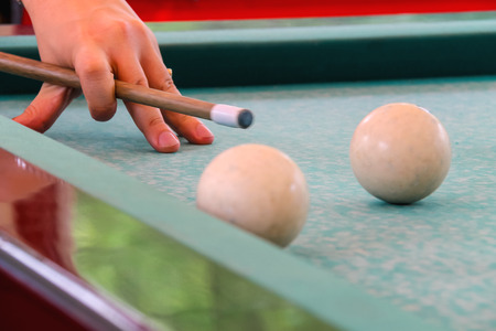 Hand with cue before the a blow to the billiard ball