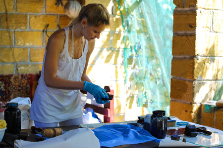 Girl gets pattern on the fabric paint in a rural  workshopの写真素材