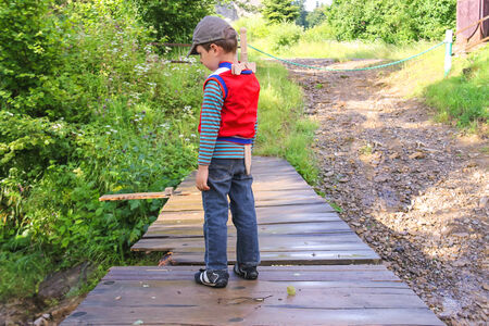 Little boy with a wooden sword in the parkの写真素材