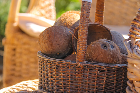 Wicker furniture and basket with coconut on the beachの写真素材