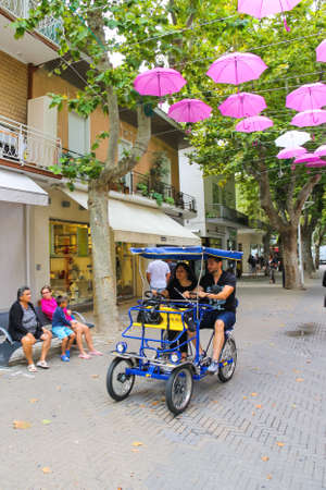 Bellaria Igea Marina, Italy - August 14, 2014: Tourists on a bicycle in the resort town Bellaria...