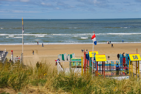 Zandvoort, the Netherlands- June 20, 2015: Tourists are walking along the sea line. Zandvoort aan Zee is a main sea resort and touristic center with a long sandy beach bordered by coastal dunes.のeditorial素材