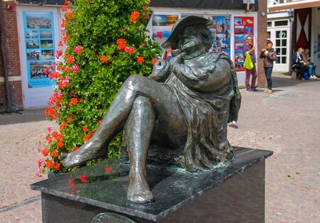 Zandvoort, the Netherlands - June 20, 2015: Bronze statue of reclining woman with bottle and glass in her hands on Kerkplein street (Madam Migraine by Rene Rikkelman)のeditorial素材