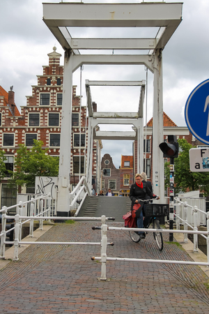 Haarlem, the Netherlands - June 20, 2015: People on the drawbridge over Spaarne river. Haarlem is the capital of the province of North Holland and popular tourist centreのeditorial素材