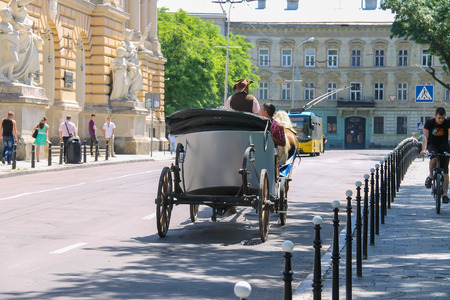 Lviv, Ukraine - July 5, 2014: Tourist carriage with people on the streets in historical city center