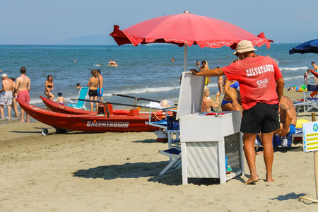 Viareggio, Italy - June 28, 2015: Beach lifeguard surrounded by resting people. Viareggio is the famous resort on the coast of the Ligurian Seaのeditorial素材