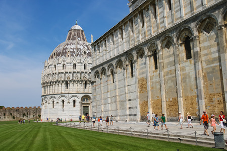 Pisa, Italy - June 29, 2015: Tourists near the Pisa Cathedral on Piazza del Duomo. View to Baptistery of St. John (Battistero di San Giovanni)のeditorial素材
