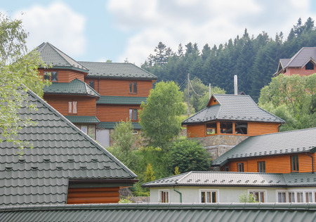 Modern cottages on slope of forested mountains. Carpathians, Ukraineの写真素材