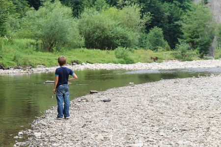 Boy near mountain river in Carpathians, Ukraineの写真素材