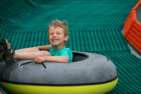 Smiling boy slides down in inflatable ringの写真素材