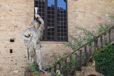 Grazzano Visconti, Italy - August 07, 2016: Old statue near stairs against stone wallのeditorial素材