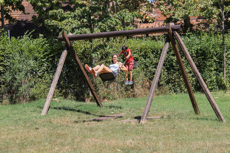 Grazzano Visconti, Italy - August 07, 2016: Children ride on wooden swingのeditorial素材