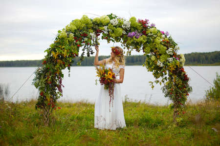 Beautiful and young girl in dress posing in the forest in the midst of a plurality of colorsの写真素材