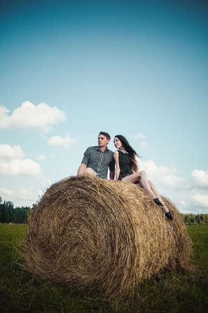 lovers resting in a field near haystacks.Outdoor portraitの写真素材