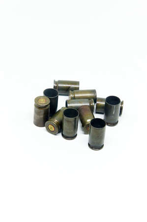 several shell casings and bullets on white background