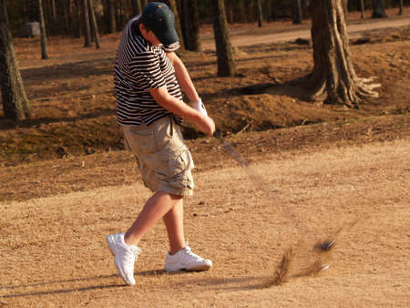 A teenager swings his golf clubの写真素材