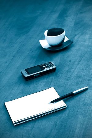 notebook pen and mobile phone with cup of coffee. blue toning の写真素材