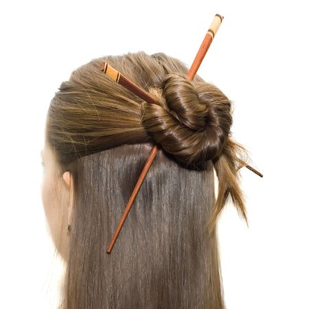 woman coiffure with asian sticks isolated on white.の写真素材