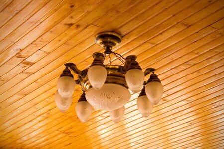 elegant chandelier on wooden ceilingの写真素材