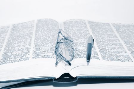 Glasses on the book with penの写真素材