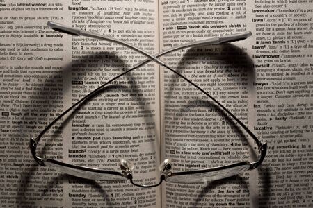 Reading glasses on an open bookの写真素材