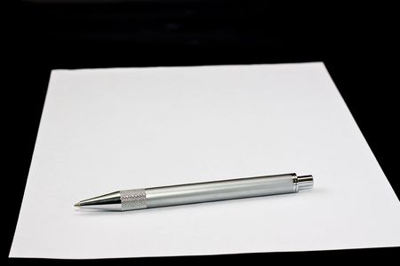 Pen on the paper over black backgroundの写真素材