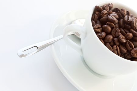 white cup with coffee beans on whiteの写真素材