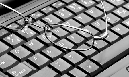 Closeup of glasses lying on the laptopの写真素材