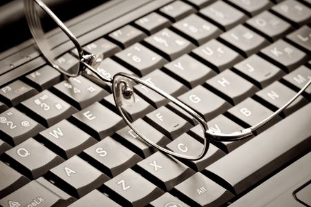 Closeup of glasses lying on the laptopの写真素材