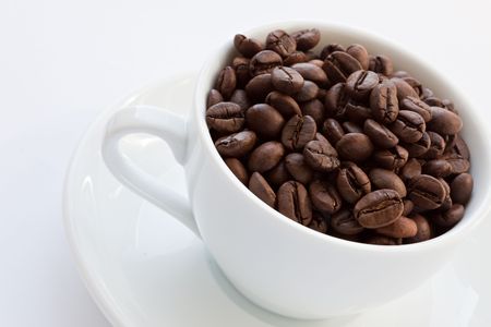 Coffee beans in a cup isolated over white backgroundの写真素材