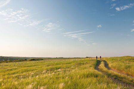 countryside view with a couple of bicyclists の写真素材