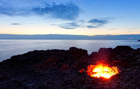 small campfire on rocky coast at night. Black sea, Crimea, Ukraineの写真素材