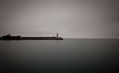 Black and white photo of pier with lighthouse. Yalta, Crimea, Ukraine