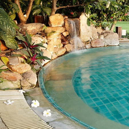 Pool with a waterfall and flowers in a resort