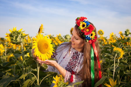 Close-up portrait of beautiful young woman with sunflowerの写真素材