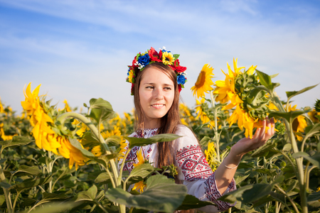 Beautiful young woman at sunflower field. Ukrainian womanの写真素材