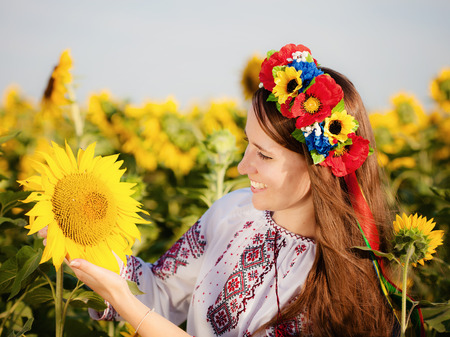 Beautiful young girl at sunflower field. Ukrainian girlの写真素材