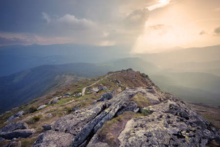 Panorama of mountain hills at cloudy sunsetの写真素材