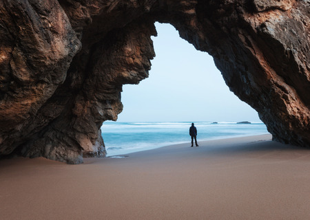 Lonely man under the rocky archの写真素材