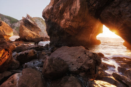 Sunlight through rock arch, Ursa beach, Portugalの写真素材