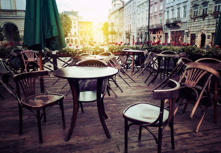 Street cafe terrace with wooden tables and chairs in European cityの写真素材