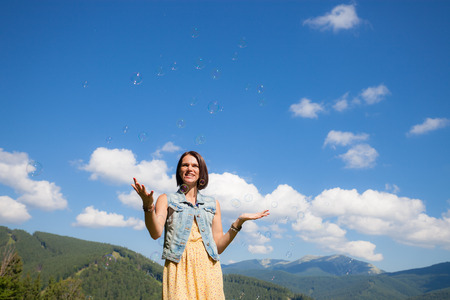 Beautiful young girl playing with soap bubbles